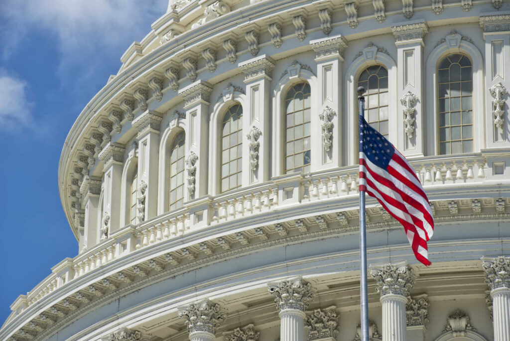 View of the U.S. Capitol building with an American flag in the foreground, symbolizing governance, public administration, and national pride in the heart of Washington, D.C.